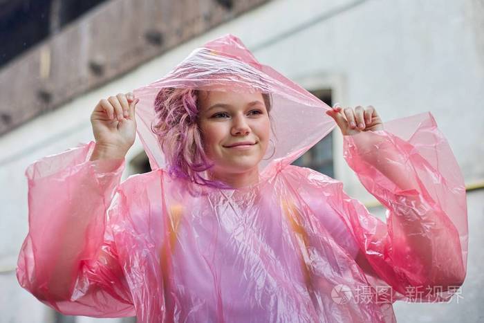 一位穿着雨衣在雨中行走的美丽少女肖像