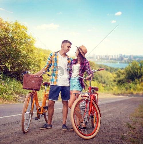 爱情夫妇在路上拥抱旧式自行车年轻男女的浪漫旅行男朋友和女一起户外