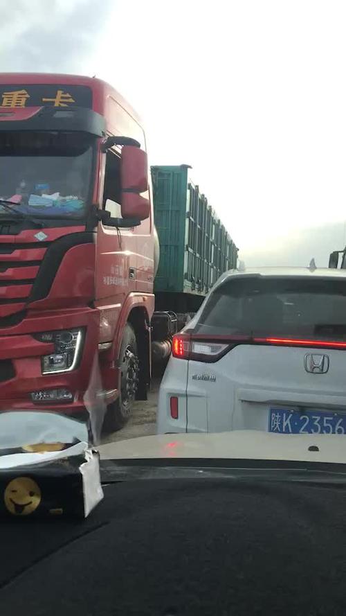 陕北榆林到神木的路上,俩边堵满了拉煤车.小车在中间行走.