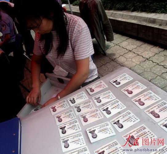 都江堰市街头,市民政部门工作人员在给受灾群众发放临时身份证